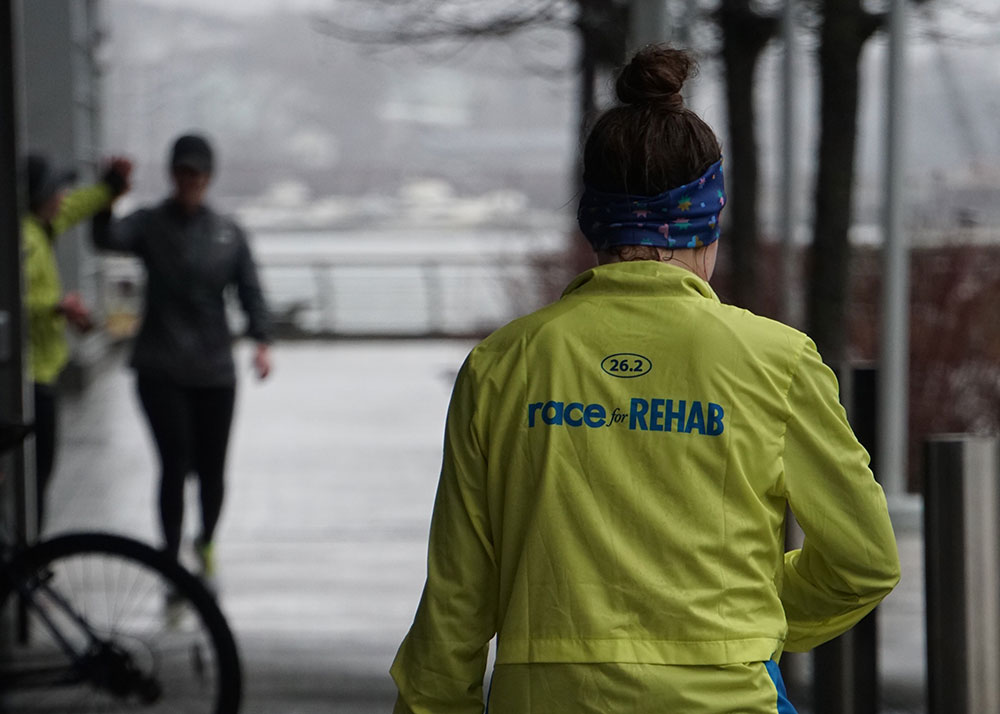 A runner in a Race for Rehab shirt, seen from behind.