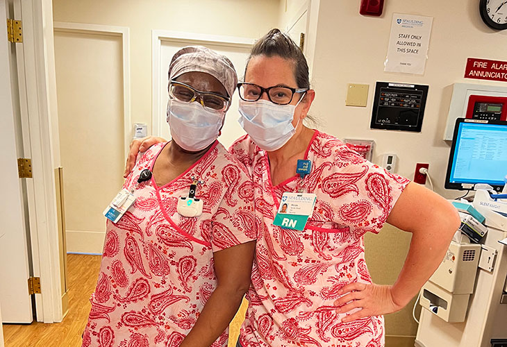 Two Brighton nurses in pink scrubs.