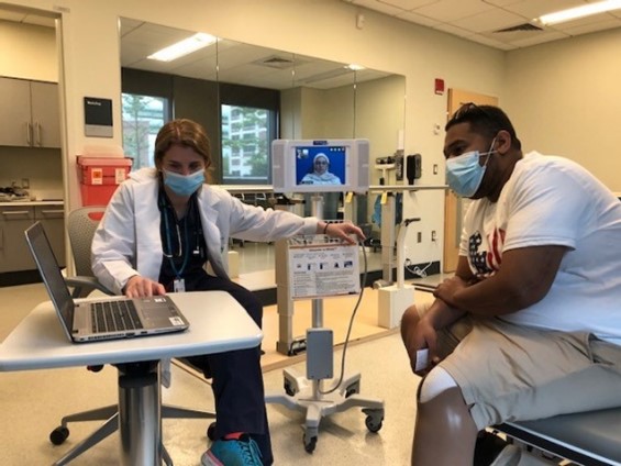 A patient and therapist look at a laptop during a therapy session.