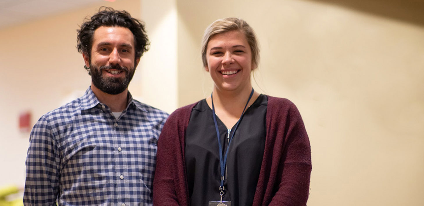 A smiling man and woman in a hospital hallway.