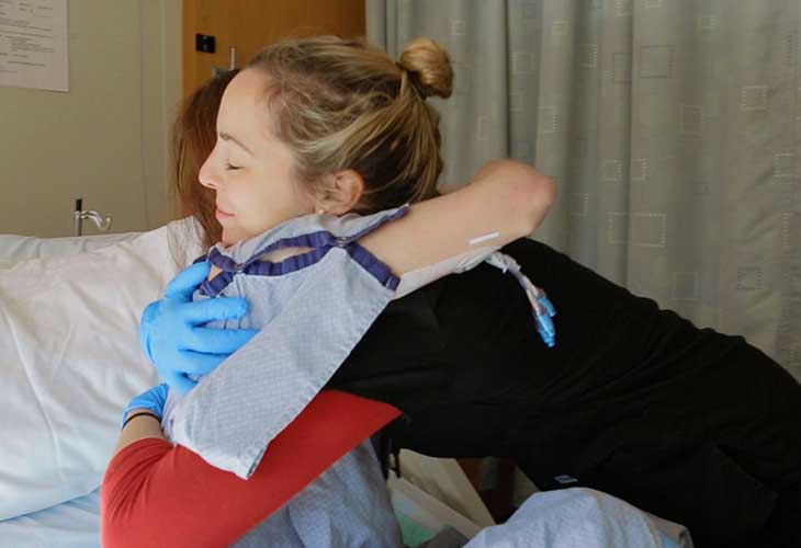 A nurse hugs a patient.