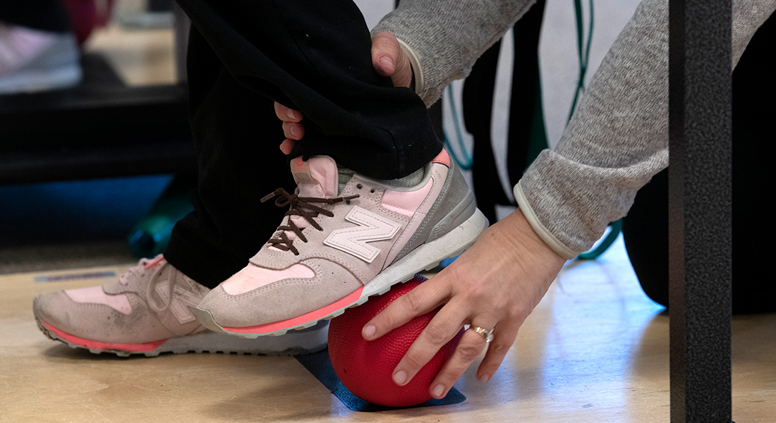 Patient rehabbing their balance with ball under foot