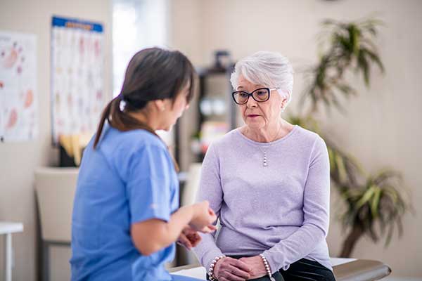 A senior woman talks to a healthcare provider