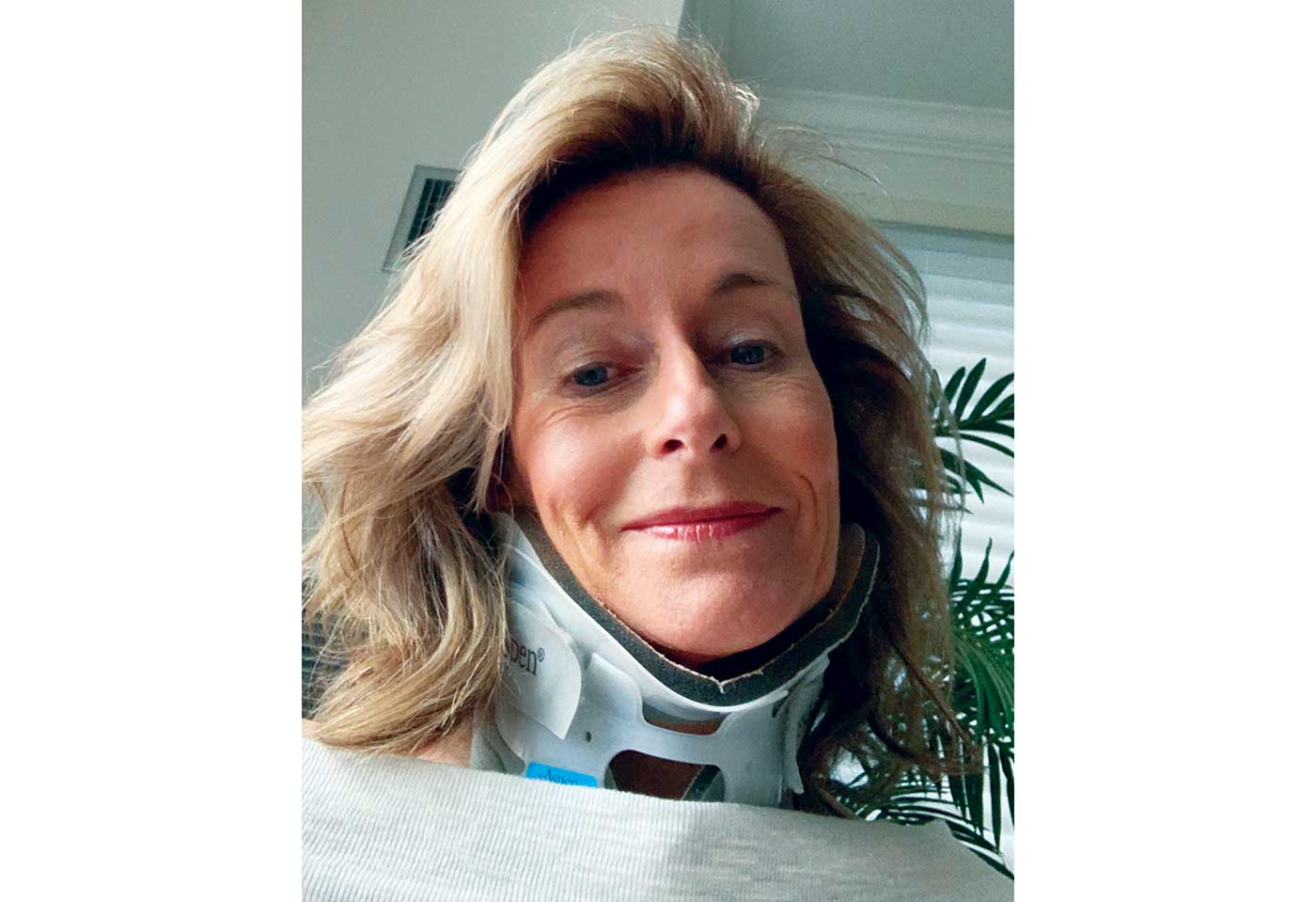 Dee, a middle-aged white woman with mid-length blond hair, wearing a neck brace.