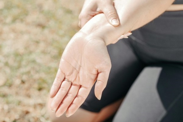A person in workout clothes holding their wrist